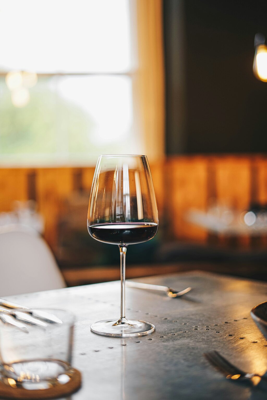 Weinglas mit Rotwein. Steiermarkt, natürlich kostbar. Ilse Stachel. Bild von Rick Barret über Unsplash.